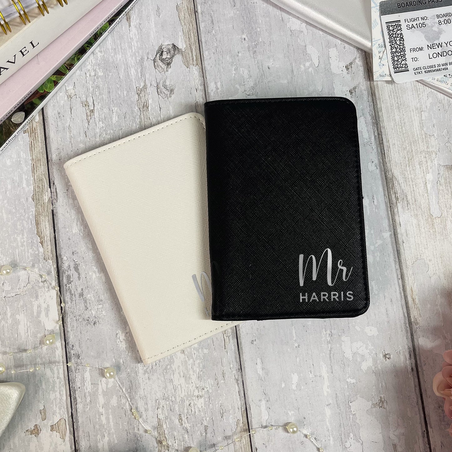 Black passport holder with 'Mr Harris' engraving on a wooden surface