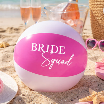 Beach ball with 'Bride Squad' text on a sandy beach with sunglasses, flip-flops, and drinks.