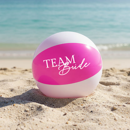 Beach ball with 'BRIDE Squad' text on a sandy beach with ocean in the background