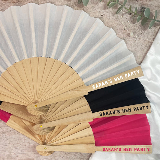 Set of personalized hand fans with 'Sarah's Hen Party' text on a neutral background.
