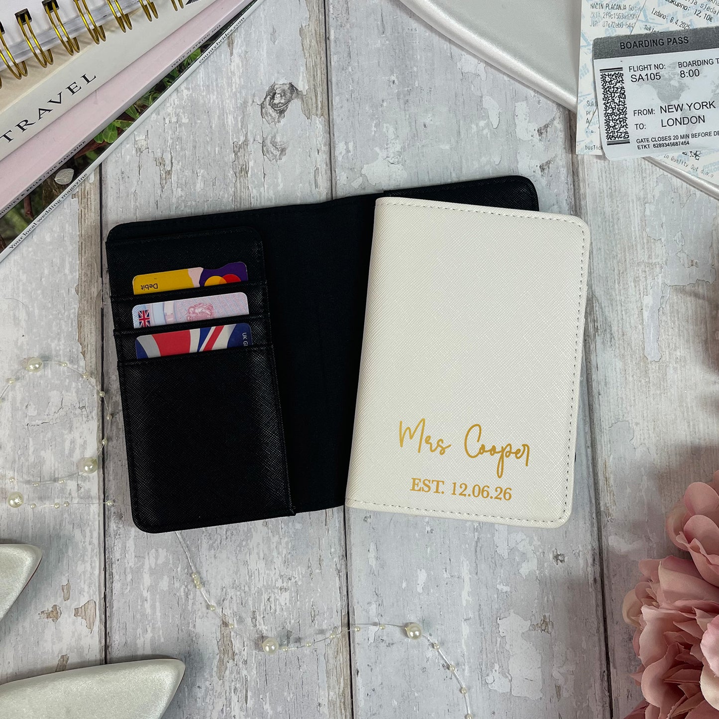 Black wallet and white passport holder with 'Mrs Cooper' engraving on a textured surface.