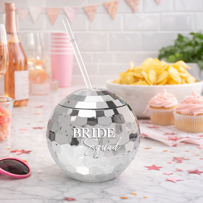 Silver disco ball tumbler with 'Bride Squad' text on a table with snacks and drinks.