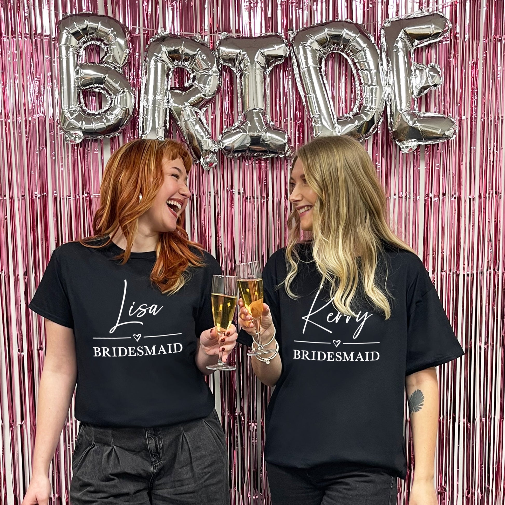 Two women wearing 'Bridesmaid' shirts with 'BRIDE' balloons in the background.