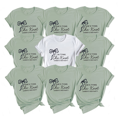 Collection of t-shirts with 'She's tying the knot' text in various colors on a white background