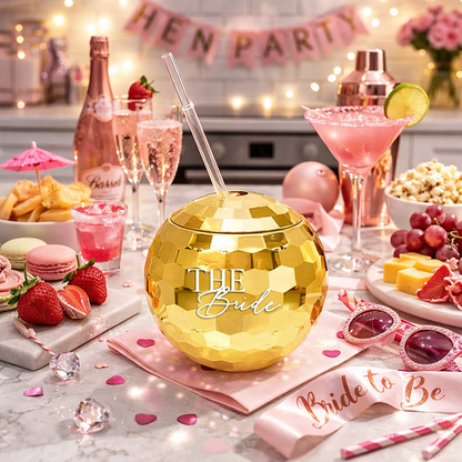 Gold disco ball with 'The Bride' text on a table with pink decorations and drinks, set up for a hen party.